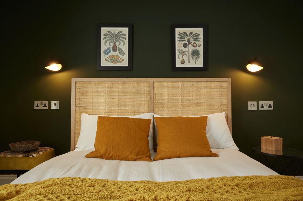 The king-sized bed, showing the feature wall behind with botanical pictures above
